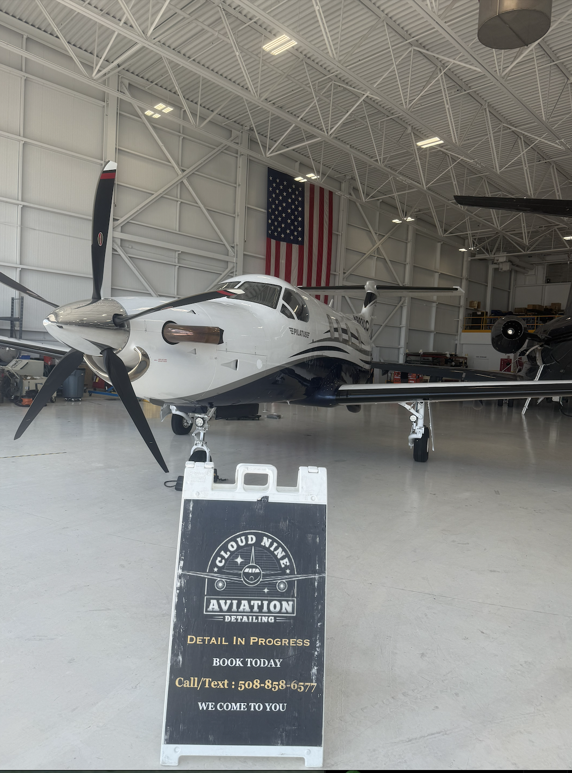 Pilatus aircraft inside a hangar with Cloud Nine Aviation detailing signage