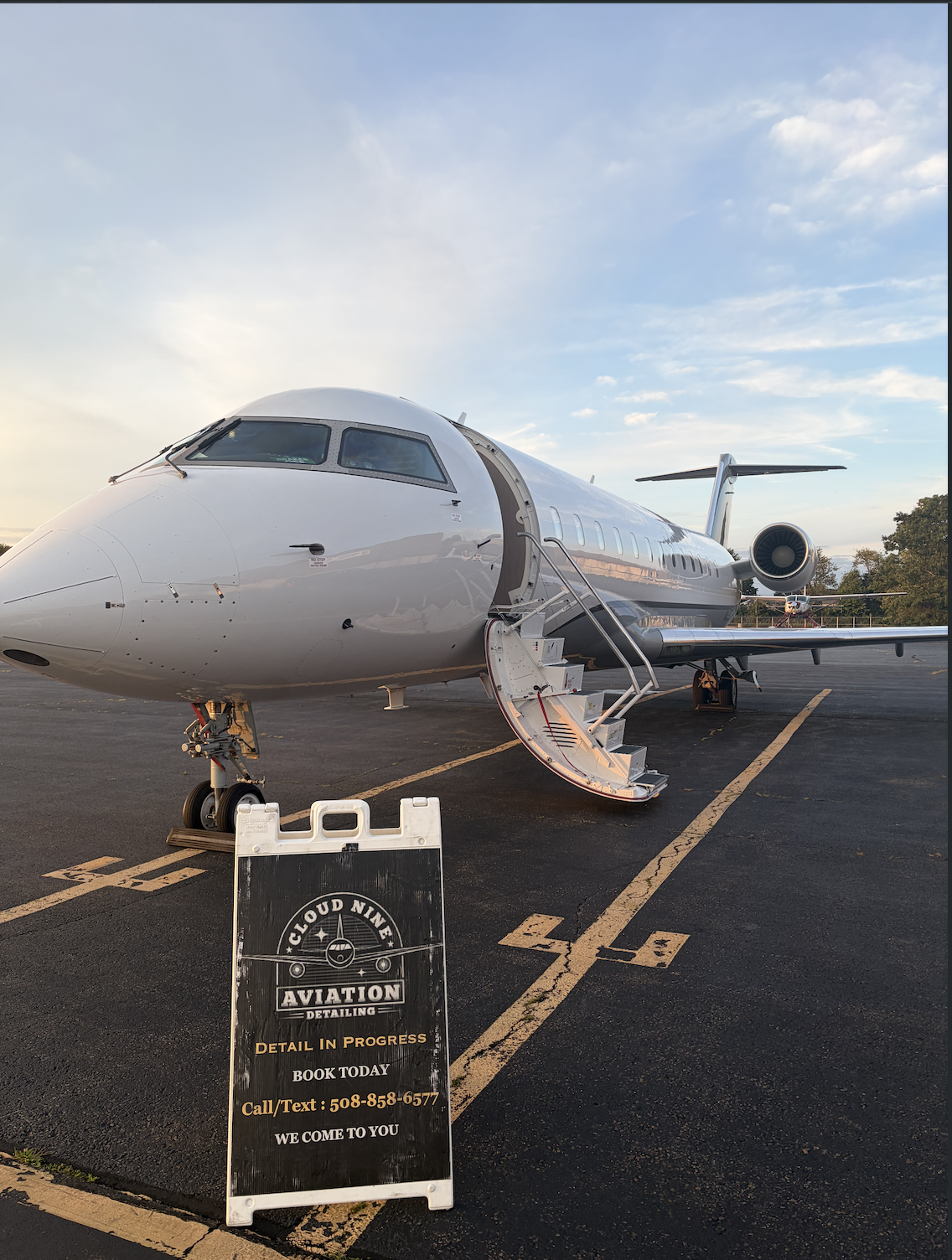 Private jet receiving aircraft detailing service on a sunset ramp