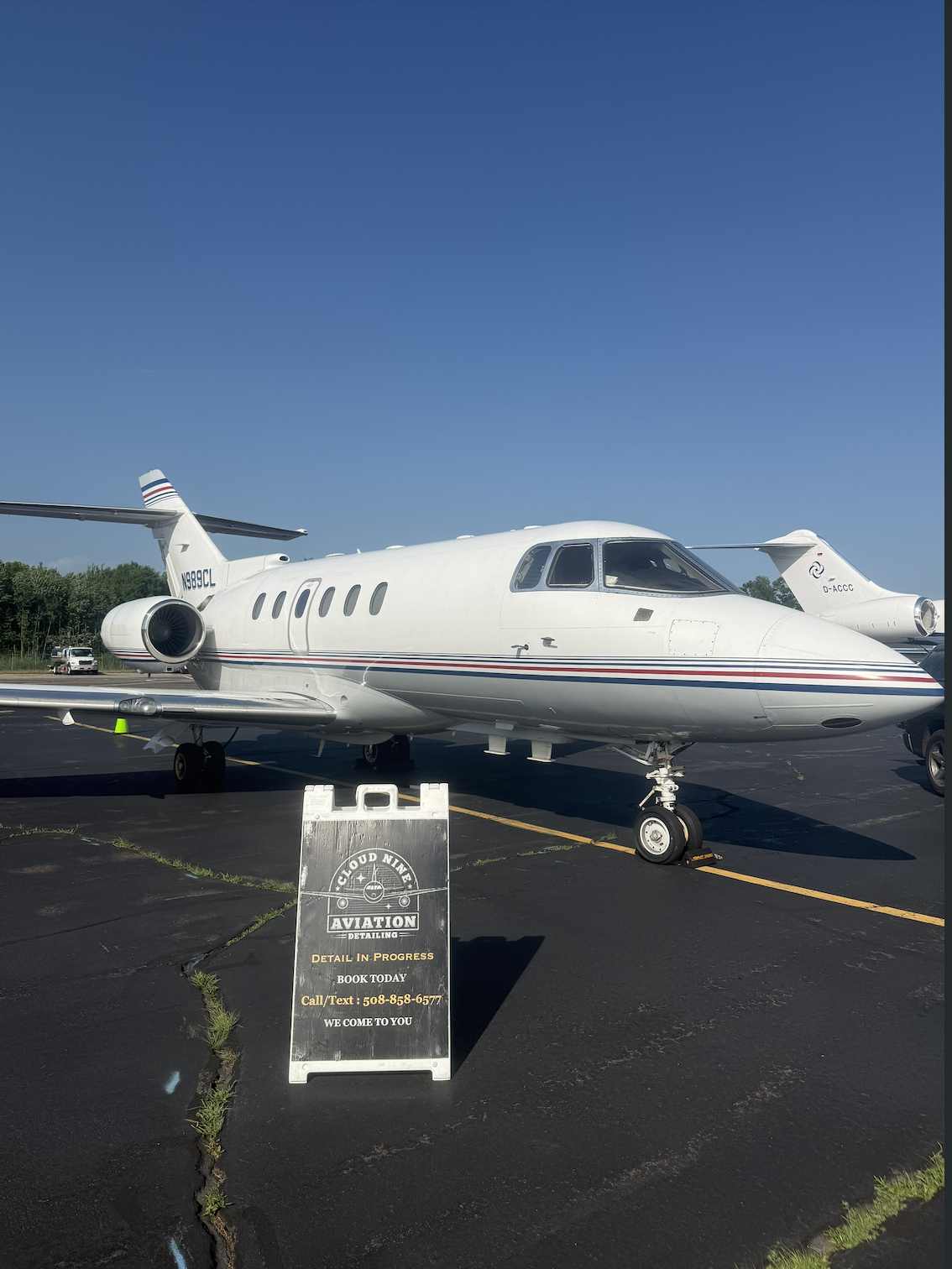 White business jet on the airport ramp during aircraft detailing